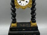 a black and gold clock sitting next to a pair of scissors