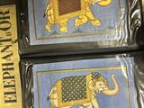two framed pictures of elephants on display in a store