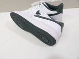 a pair of white and green sneakers on a table