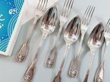 six silver spoons and six silver spoons on a table