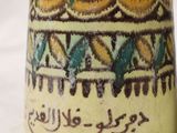 a yellow vase with blue and green designs on it