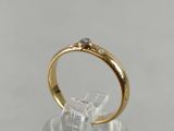 a close up of a gold ring with a diamond on it