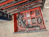a red tool box with tools in it on the floor