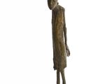 statue d'un homme debout sur un socle carré, les mains dans les poches