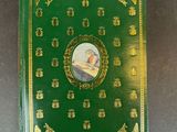 a green book with gold trim and a picture of a bird on it