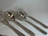 five silver spoons and two silver spoons on a white table
