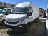 une camionnette blanche garée à côté d'autres camionnettes sur un parking