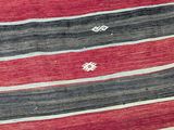 an image of a red, black and white striped rug on a wooden floor