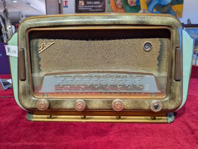 une radio à l'ancienne posée sur un tapis rouge