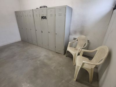 deux chaises dans une pièce, avec des casiers en arrière-plan
