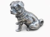silver figurine of a dog sitting on a white surface