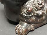 a bronze statue of a dog with a mouth open