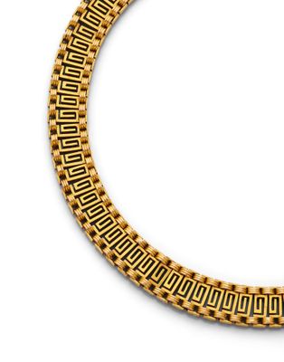 gros plan d'un collier en or sur fond blanc