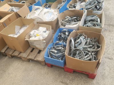 de nombreuses caisses contenant divers objets métalliques, posées sur une palette
