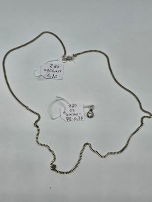 two necklaces with tags attached to them on a white surface