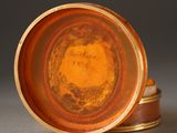 a brown plate with a gold rim on a gray surface