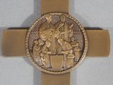 gold plated cross with a picture of a man riding a horse on it