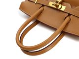 a close up of a brown handbag with a gold clasp