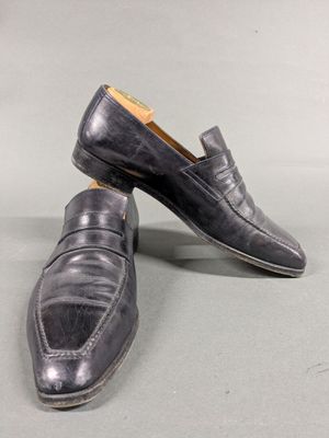 men ' s black loafer shoes with leather soles on a grey surface