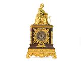 une horloge en or surmontée d'une statue