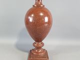 un vase marron posé sur une table blanche