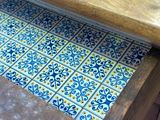 a wooden table with a blue and yellow tile on it