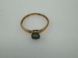 a close up of a gold ring with a green stone