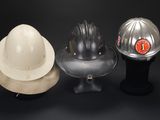 three hard hats sitting on top of a black table