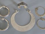 plusieurs bagues en argent et un collier en argent posés sur une table