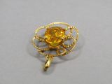 une image représentant une broche en or ornée d'un motif floral