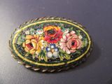 une photo d'une broche ornée de fleurs