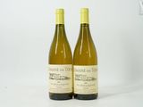 deux bouteilles de vin blanc posées l'une à côté de l'autre sur une surface blanche