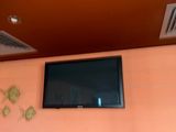 a flat screen tv mounted on the wall above a sink