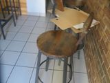 a pizza box sitting on top of a stool in front of a brick wall