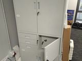 a filing cabinet with two doors open in a room