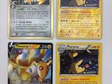 Quatre cartes Pokémon sont posées sur une table avec un fond blanc.