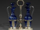 pair of blue glass vases on a stand with a silver base