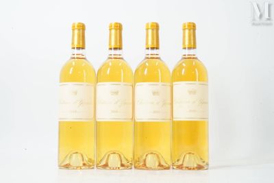 quatre bouteilles de vin sont alignées sur une surface blanche