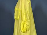 a yellow shirt on a mannequin stand against a blue wall