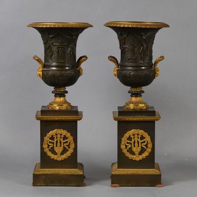 pair of black and gold vases on pedestals with numbers 50 and 50