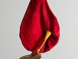 a red cloth bag with a wooden handle hanging from it