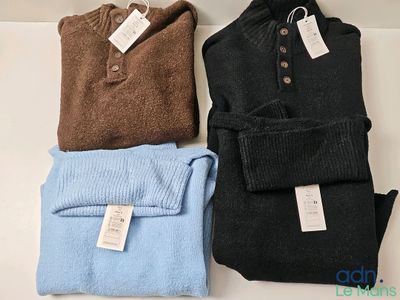 trois pulls pour homme posés sur une table, avec des étiquettes dessus