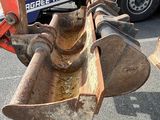 a tractor that is sitting in the street with a bucket attached to it