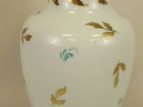 a white vase with a gold leaf design on it