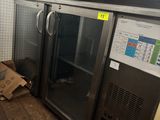une boîte de pizza posée par terre à côté d'un réfrigérateur