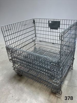 a large metal cage with wheels on the floor