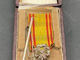 une image représentant une boîte contenant une médaille et un stylo