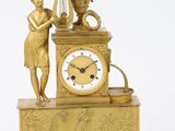 une horloge en or surmontée d'une statue
