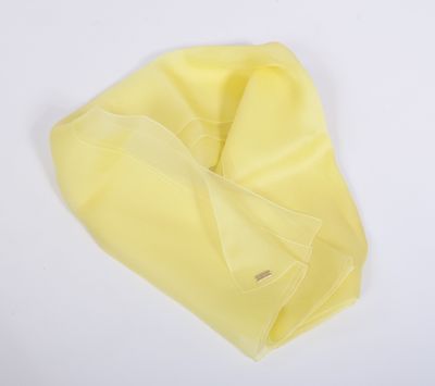 L'écharpe jaune est posée sur une surface blanche.