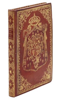 un vieux livre sur lequel figurent des armoiries et une couronne